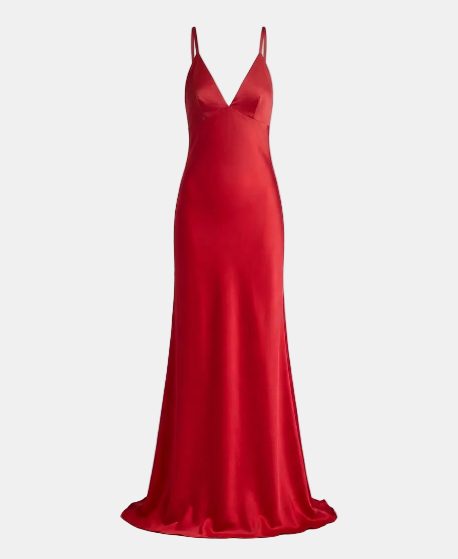 A floor-length red satin slip dress with thin spaghetti straps and a deep V-neckline, displayed on a neutral gray background.