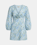 A light blue floral long-sleeve dress with a V-neckline, gathered waist, and a fabric rose detail at the chest, shown on a light gray background.
