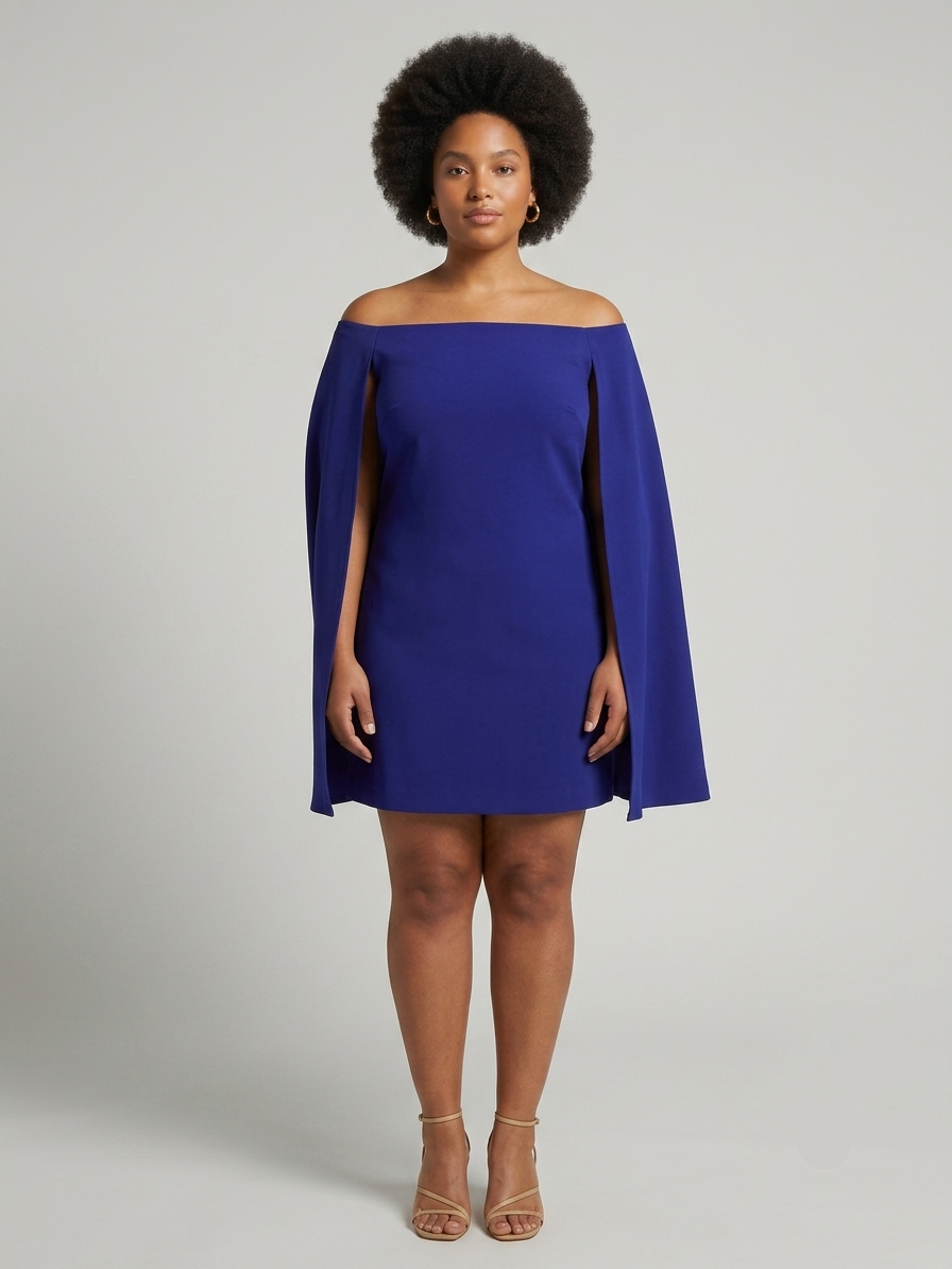 A woman modeling a royal blue off-the-shoulder cape mini dress against a neutral light gray studio background.