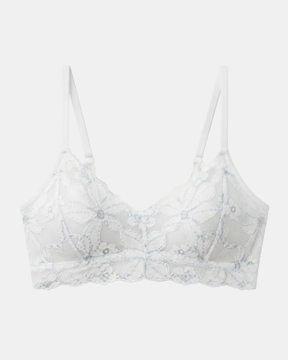 White floral lace underwire bra with thin adjustable shoulder straps and a scalloped lace hem, shown flat against a light gray background.