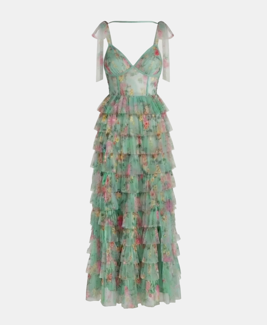 A long tiered tulle dress in mint green with a pink and yellow floral print, featuring thin shoulder straps with bow details, shown against a plain light gray background.