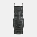 A black ruched faux-leather bodycon mini dress with thin spaghetti straps, shown against a solid light gray background.