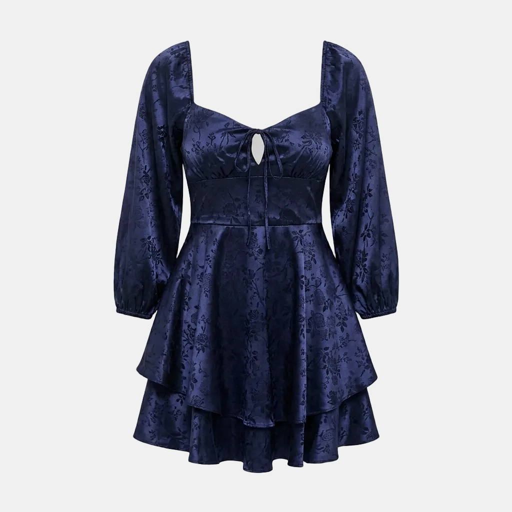 A dark navy blue brocade dress with a square neckline, long puff sleeves, a keyhole cutout at the bust, and a tiered ruffled skirt, shown against a solid gray background.